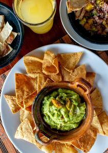 a plate with a bowl of guacamole and chips at Hotel Zentik Project & Saline Cave in Valladolid