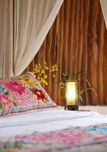a lamp sitting on a bed next to a pillow at Hotel Zentik Project & Saline Cave in Valladolid