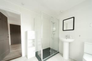 a bathroom with a glass shower and a sink at The Lodge in Walberswick +43 photos
