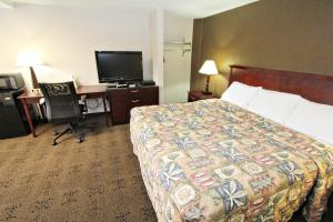 a hotel room with a bed and a desk and a television at Knights Inn Pine Grove I-81 Exit 100 in Pine Grove