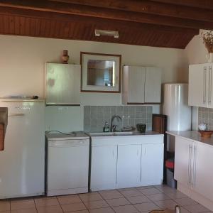 a kitchen with white cabinets and a sink and a dishwasher at Maisons du Père Paille in Usclades +13 photos