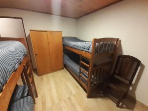 Zimmer mit einem Etagenbett und einem Schreibtisch sowie einem Zimmer mit einem Bett in der Unterkunft Alojamiento Los Alelies in San Carlos de Bariloche