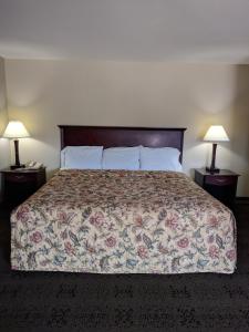 a bed in a hotel room with two lamps at Knights Inn Pine Grove I-81 Exit 100 in Pine Grove