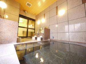 a large room with a swimming pool in a building at Hotel Route-Inn Shimodate in Chikusei