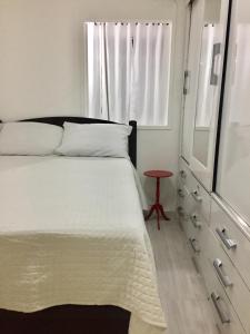 a bedroom with a bed and a dresser and a window at Apartamento Duvivier in Rio de Janeiro