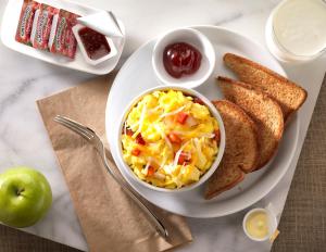 un plato de comida con un tazón de huevos y tostadas en Home2 Suites By Hilton Joplin, MO, en Joplin