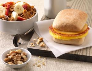 a breakfast sandwich and a bowl of fruit and nuts at Home2 Suites By Hilton Joplin, MO in Joplin