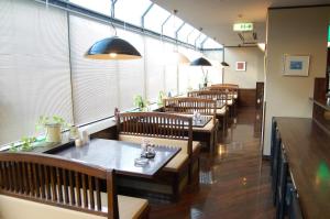 una fila de mesas y bancos en un restaurante en HOTEL ROUTE-INN Ueda - Route 18 -, en Ueda