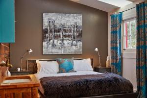 a bedroom with a bed and a painting on the wall at The Factory Luxury Accomodation in Kaikoura