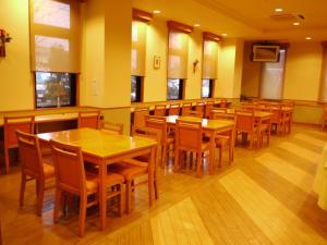 une salle à manger avec des tables et des chaises en bois dans l'établissement Hotel Route-Inn Jouetsu, à Joetsu