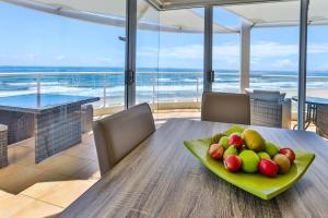 a plate of fruit on a table in a dining room at Regency on the Beach in Gold Coast