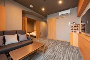 ein Wohnzimmer mit einem Sofa und einem Tisch in der Unterkunft Hotel Apple Land in Hirakawa