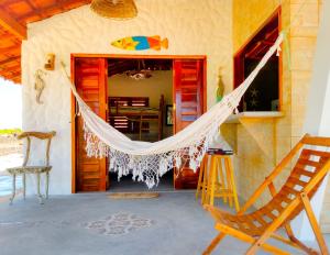 a porch with a hammock hanging from a house at Flats Macapá Meu Amor in Luis Correia