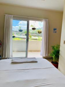 a bedroom with a bed and a large window at Palmira Hostel in Tegucigalpa