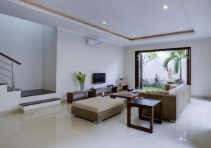 a living room with a couch and a tv at White Lotus Villas Seminyak in Seminyak