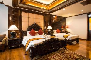 a bedroom with two beds in a room at Villa Sirilanna Hotel in Chiang Mai
