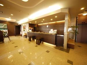 a restaurant with a counter and tables in a lobby at Hotel Route-Inn Suwa-Inter2 in Suwa