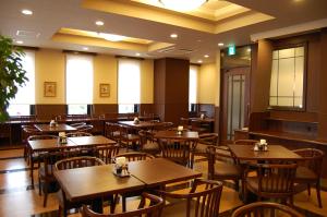 una sala da pranzo con tavoli e sedie in legno di Hotel Route-Inn Nagahama Inter a Nagahama