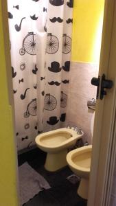 ein Badezimmer mit einem WC und einem Duschvorhang mit Hüten in der Unterkunft Santorini Bed en Córdoba in Cordoba