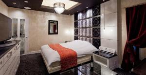 a bedroom with a bed and a tv and a window at Hotel Cherena Kunitachi (Adult Only) in Kunitachi