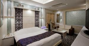 a hotel room with a bed and a couch at Hotel Cherena Kunitachi (Adult Only) in Kunitachi