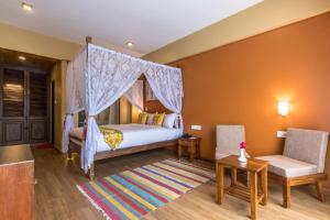 a bedroom with a bed with a canopy at Hotel Mala Pokhara in Pokhara