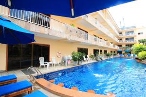 a large swimming pool with chairs and an umbrella at Baan Boa Resort in Patong Beach