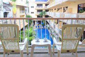 a balcony with two chairs and a table and a pool at Baan Boa Resort in Patong Beach