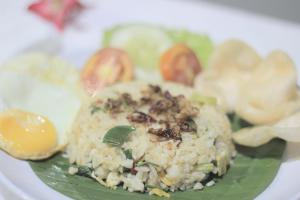 a plate of food with rice and eggs and vegetables at Wisma Andany in Jepara