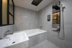y baño con bañera blanca y lavamanos. en 2Night Business Hotel, en Jeonju