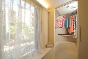 a bathroom with a window and a closet with clothes at BV Taipei XinYi D in Taipei +37 photos