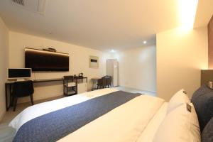 a hotel room with a large bed and a television at 2Night Business Hotel in Jeonju