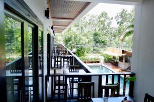 un balcone con tavoli, sedie e piscina di Aiya Resort Koh-Tao a Ko Tao