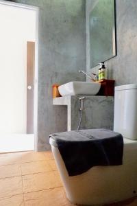 baño con lavabo y aseo con espejo en Aiya Resort Koh-Tao, en Ko Tao