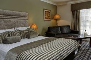 a hotel room with a large bed and a couch at Best Western Plus West Retford Hotel in Retford