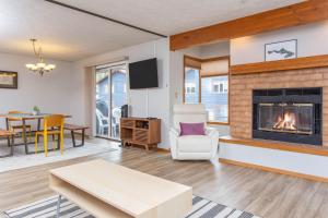 a living room with a fireplace and a table at Timberline 208 in Girdwood
