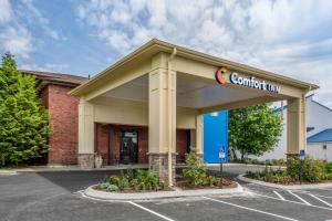 Comfort Inn Ellsworth - Bar Harbor في إلسورث: مبنى تجاري مع علامة نزل ثقة في موقف للسيارات