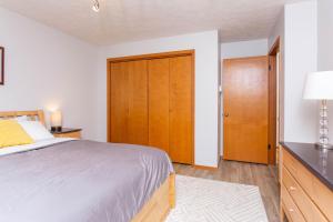 a bedroom with a bed and a wooden closet at Timberline 208 in Girdwood