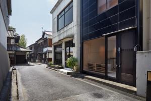 una strada vuota con un edificio con finestre di 滔々 御崎 二階の宿 toutou Onzaki Nikai no Yado a Kurashiki