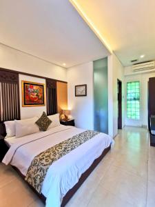 a bedroom with a large bed in a room at Yulia Village Inn Ubud in Ubud