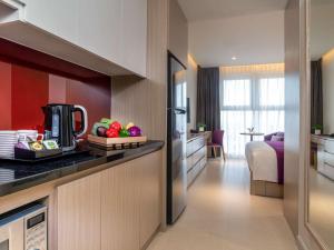 a hotel room with a kitchen and a bedroom at Mercure Hai Phong in Hai Phong