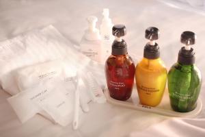 a tray with three bottles of detergent and other cleaning products at Hotel Quest Shimizu in Shizuoka