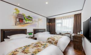 pokój hotelowy z dwoma łóżkami i telewizorem w obiekcie Nostalgia Hotel (Prince Gong Mansion) w Pekinie