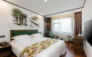 una camera d'albergo con un grande letto e una scrivania di Nostalgia Hotel (Prince Gong Mansion) a Pechino