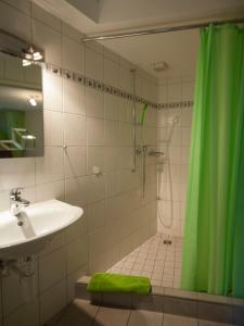 ein Badezimmer mit einem grünen Duschvorhang und einem Waschbecken in der Unterkunft Bergwerksilo Herznach in Herznach