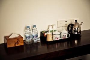 - un comptoir avec des bouteilles d'eau et une cafetière dans l'établissement Nostalgia Hotel (Prince Gong Mansion), à Pékin