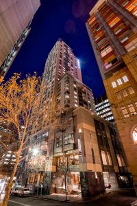 a tall building in a city at night at Amora Hotel Jamison Sydney in Sydney