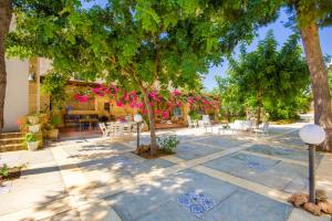 a patio with tables and chairs under trees at Villa Baglio in Marsala +25 photos