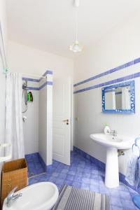 a blue and white bathroom with a sink and a toilet at Villa Baglio in Marsala
