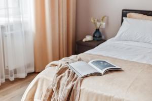 a book sitting on the end of a bed at Central Barkar Apartments in Odesa